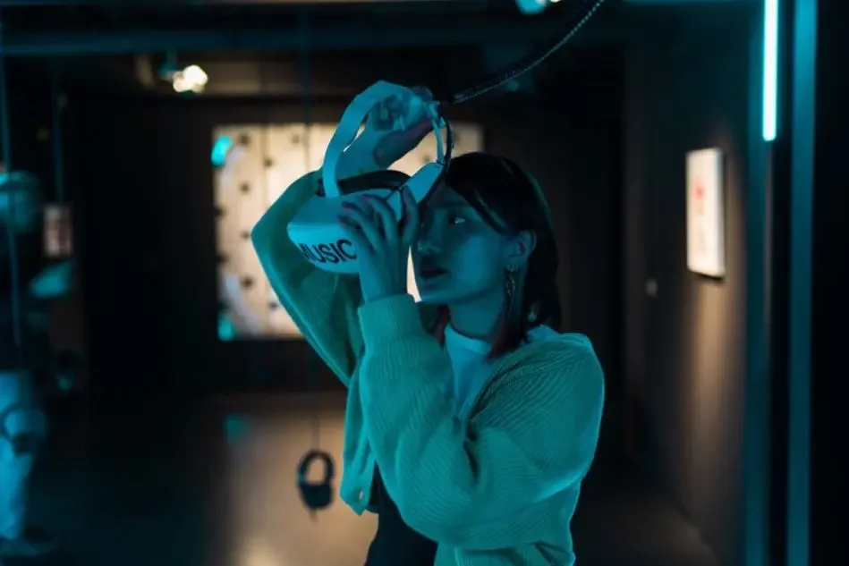 Frau, die VR-Brille mit der Aufschrift "MUSIC" aufsetzt